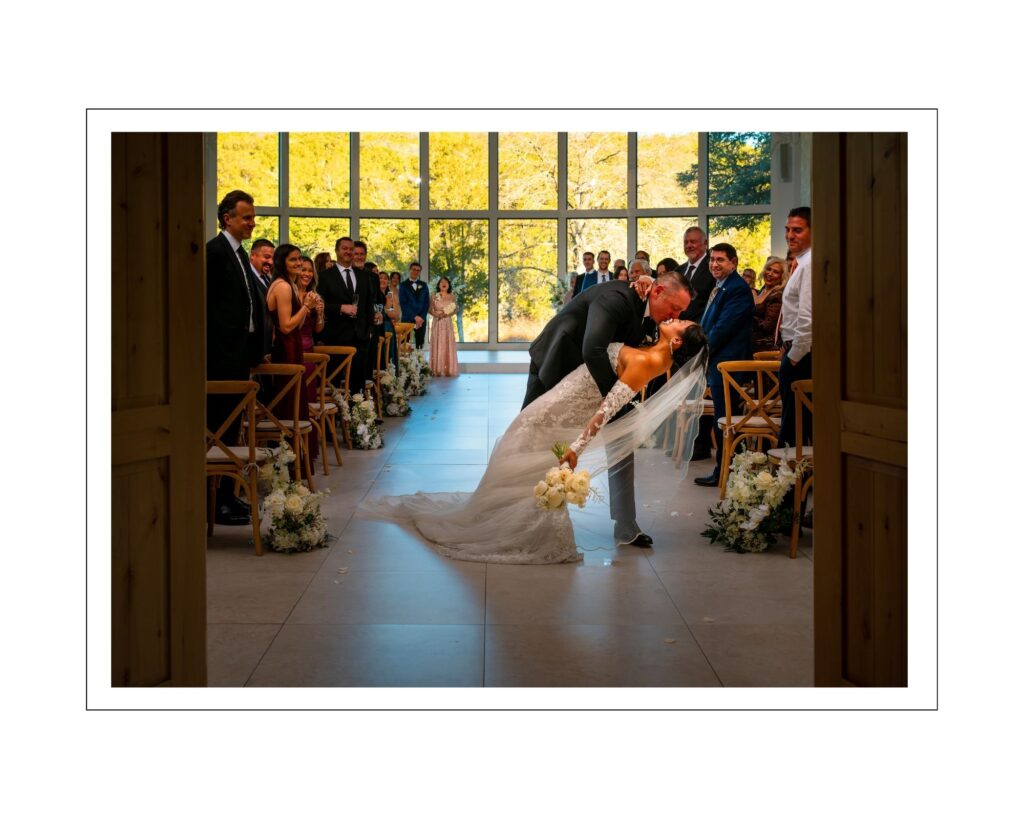Sharlene and Chip sharing a joyful dip kiss during their wedding ceremony at The Preserve at Canyon Lake