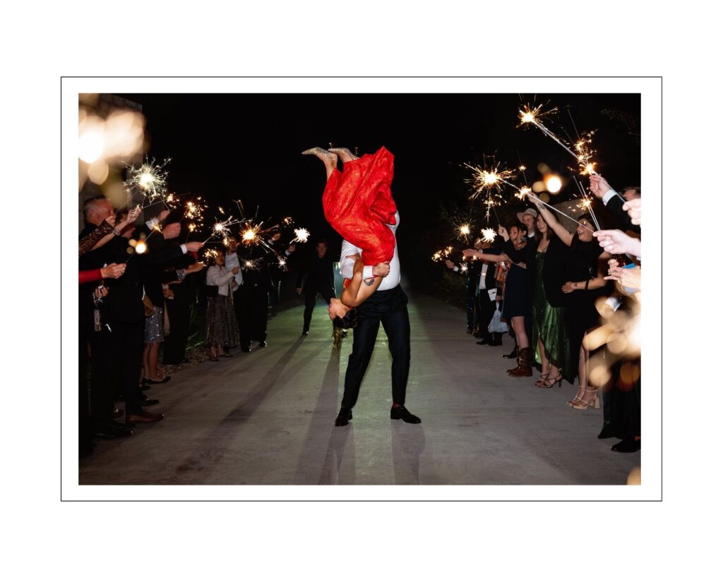 Sharlene and Chip sharing a dramatic sparkler exit as Chip flips Sharlene into the air at the end of their wedding celebration at The Preserve at Canyon Lake
