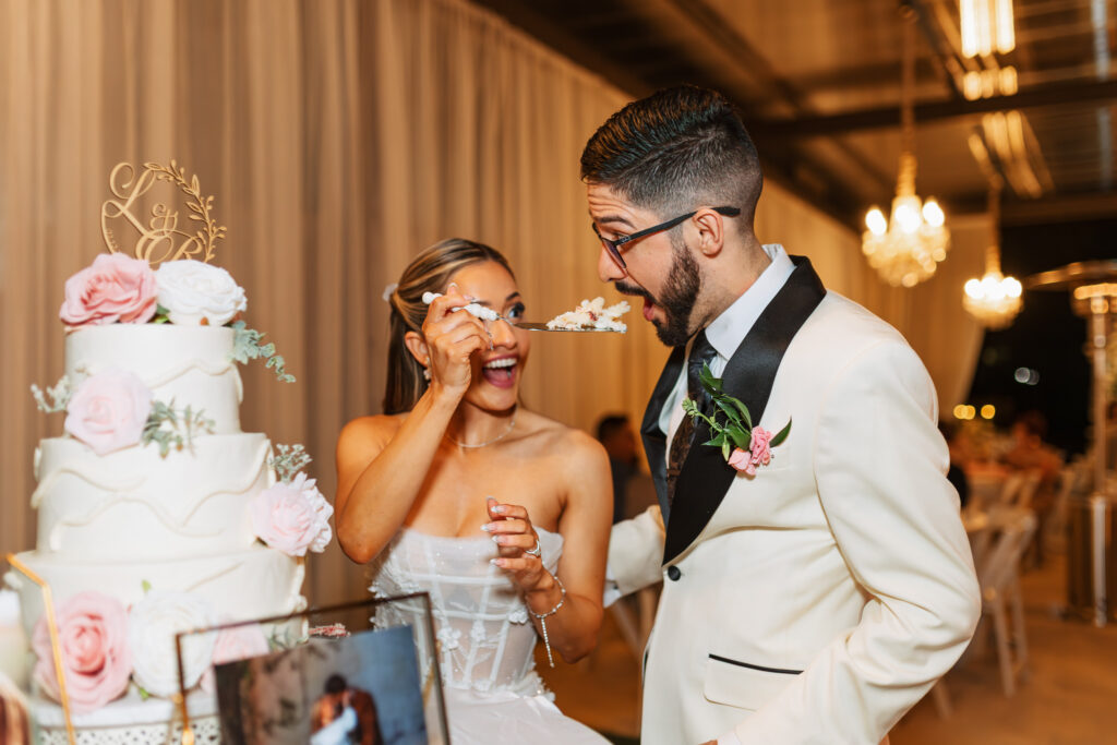 San Antonio wedding photographer captures bride laughing as groom smashes wedding cake during reception at Texas wedding